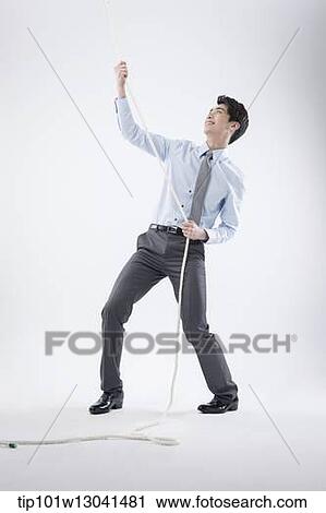 Stock Image - a business man pulling a wire. Fotosearch