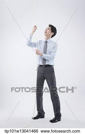 a business man pulling a wire View Large Photo Image Stock Photograph - a business man pulling a wire. Fotosearch