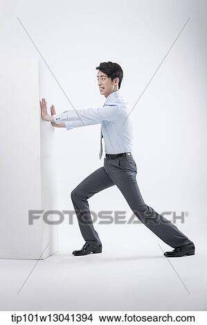 Picture - a business man pushing a block. Fotosearch