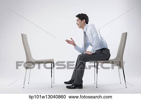 a business man sitting and talking to an empty chair View Large Photo Image Stock Image - a business man sitting and talking to an empty chair. Fotosearch