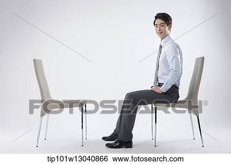 a business man sitting and talking to an empty chair View Large Photo Image Stock Photograph - a business man sitting and talking to an empty chair. Fotosearch