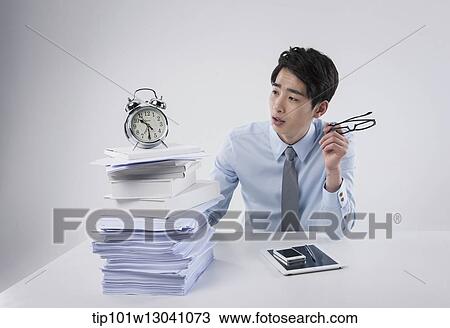 Stock Image - a business man sitting at a desk. Fotosearch