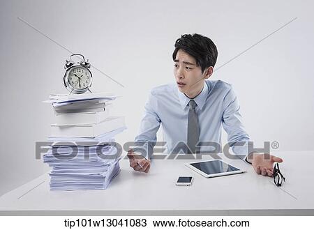 a business man sitting at a desk View Large Photo Image Stock Image - a business man sitting at a desk. Fotosearch
