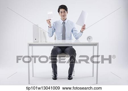 a business man sitting at a desk View Large Photo Image Stock Photo - a business man sitting at a desk. Fotosearch