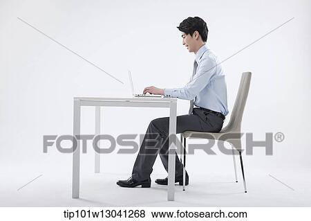 a business man sitting at a desk View Large Photo Image Stock Photo - a business man sitting at a desk. Fotosearch