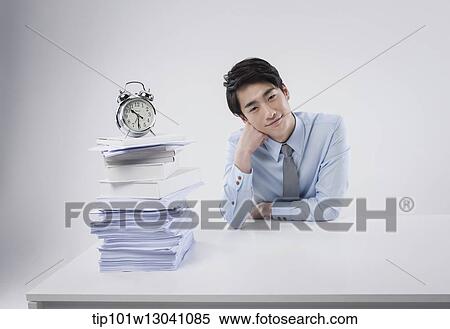 Stock Photography - a business man sitting at a desk. Fotosearch