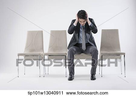 Stock Image - a business man sitting on a chair. Fotosearch
