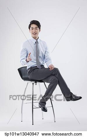 Stock Photo - a business man sitting on a chair. Fotosearch