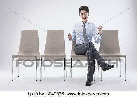 Stock Photograph - a business man sitting on a chair. Fotosearch