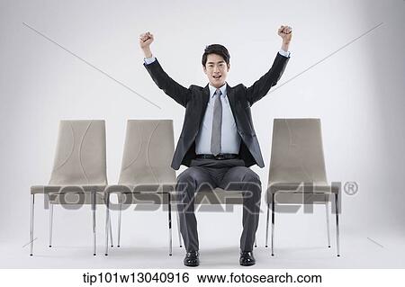 Stock Photograph - a business man sitting on a chair. Fotosearch