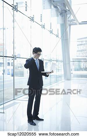 a business man standing with a laptop View Large Photo Image Stock Photography - a business man standing with a laptop. Fotosearch