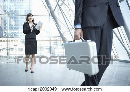 Stock Image - a business man walking away from a woman. Fotosearch