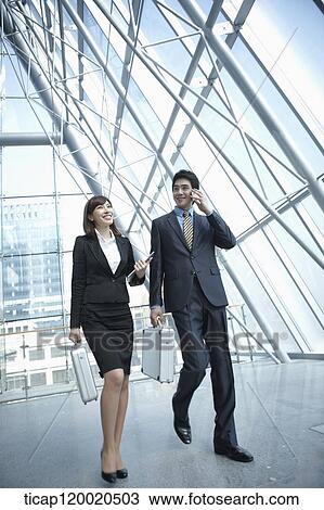 Stock Image - a business man walking with a business woman. Fotosearch