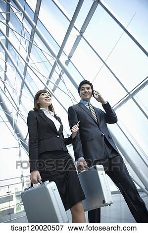 Stock Photo - a business man walking with a business woman. Fotosearch