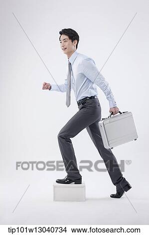 Picture - a business man with a case. Fotosearch