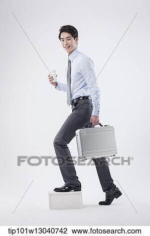 Stock Image - a business man with a case. Fotosearch