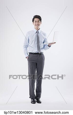 Stock Image - a business man with a laptop. Fotosearch