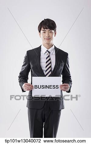 Stock Image - a business man with a paper saying business. Fotosearch