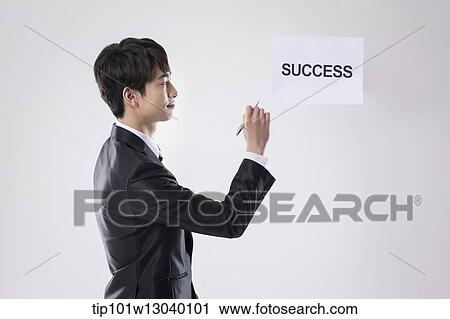 Stock Image - a business man with a paper saying success. Fotosearch