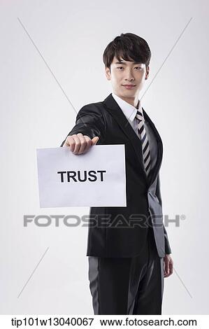 a business man with a paper saying trust View Large Photo Image Stock Photo - a business man with a paper saying trust. Fotosearch