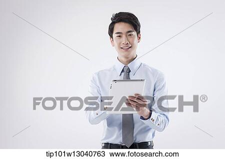 Stock Image - a business man with a tablet. Fotosearch
