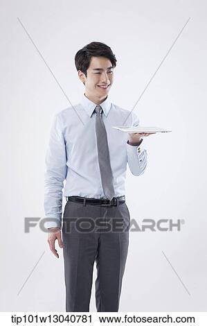 Stock Image - a business man with a tablet. Fotosearch