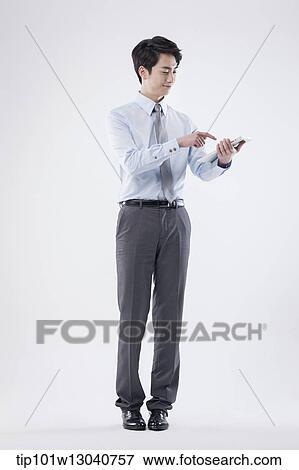 Stock Photo - a business man with a tablet. Fotosearch