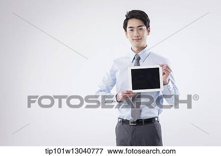 Stock Photo - a business man with a tablet. Fotosearch