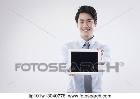 Stock Photo - a business man with a tablet. Fotosearch
