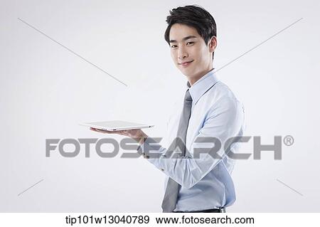 Stock Photo - a business man with a tablet. Fotosearch