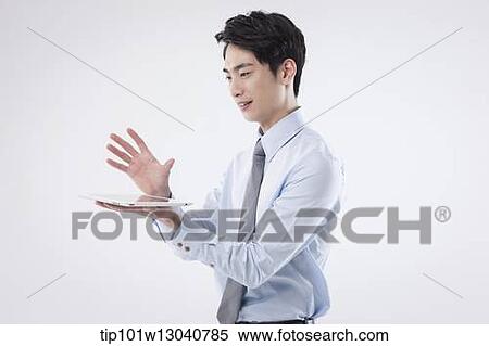 Stock Photography - a business man with a tablet. Fotosearch