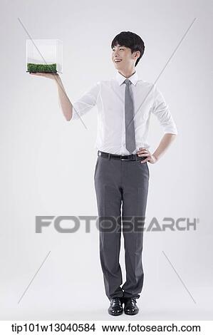 a business man with a transparent box of grass View Large Photo Image Picture - a business man with a transparent box of grass. Fotosearch