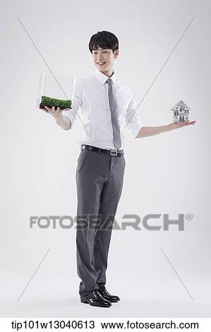 a business man with a transparent box of grass and a house of money View Large Photo Image Stock Image - a business man with a transparent box of grass and a house of money. Fotosearch