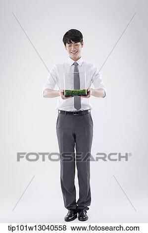 Stock Photo - a business man with a transparent box of grass. Fotosearch