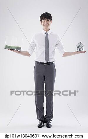 a business man with a transparent box of grass and a house of money View Large Photo Image Stock Photo - a business man with a transparent box of grass and a house of money. Fotosearch