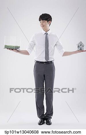 a business man with a transparent box of grass and a house of money View Large Photo Image Stock Photo - a business man with a transparent box of grass and a house of money. Fotosearch