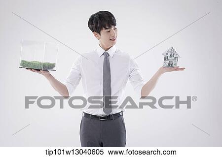 a business man with a transparent box of grass and a house of money View Large Photo Image Stock Photography - a business man with a transparent box of grass and a house of money. Fotosearch