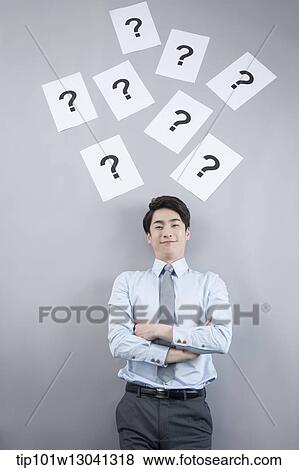 Stock Photo - a business man with papers that has a question mark. Fotosearch