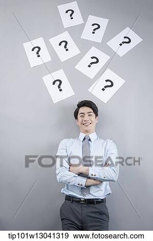 Stock Photo - a business man with papers that has a question mark. Fotosearch