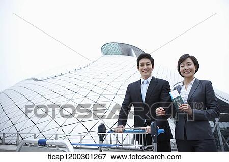 a businessman and businesswoman with baggage cart at the airport View Large Photo Image Stock Photo - a businessman and businesswoman with baggage cart at the airport. Fotosearch