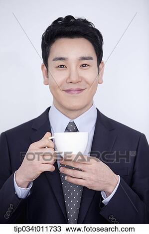 Stock Image - a businessman drinking cup of coffee. Fotosearch
