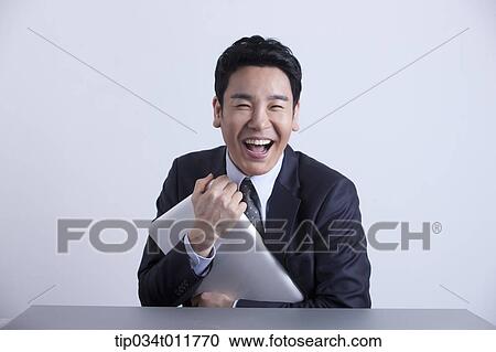 Stock Image - a businessman happily hugging a laptop. Fotosearch