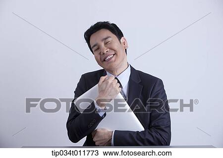 a businessman happily hugging a laptop View Large Photo Image Stock Image - a businessman happily hugging a laptop. Fotosearch