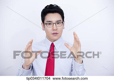Picture - a businessman in business suit explaining using hand gesture. Fotosearch