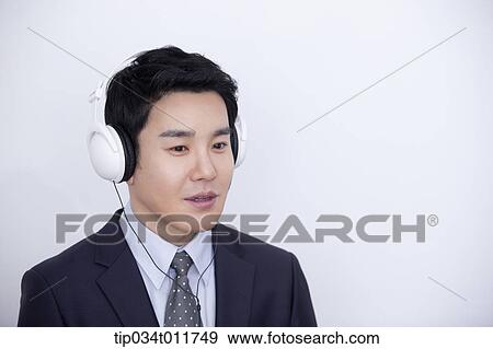 a businessman listening with a headset on View Large Photo Image Stock Photo - a businessman listening with a headset on. Fotosearch