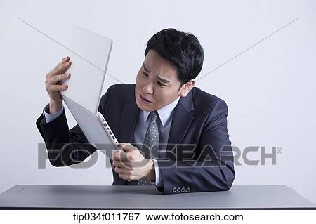 Stock Photo - a businessman looking frustrated with a laptop. Fotosearch