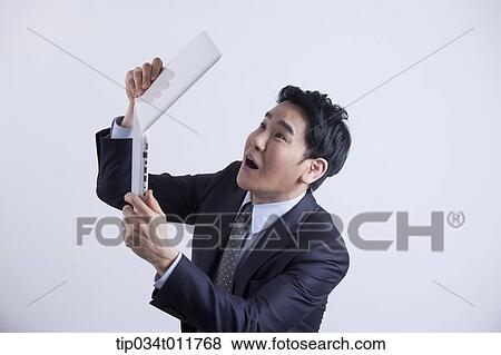 Stock Photo - a businessman looking frustrated with a laptop. Fotosearch