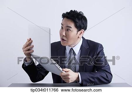 a businessman looking frustrated with a laptop View Large Photo Image Stock Photograph - a businessman looking frustrated with a laptop. Fotosearch