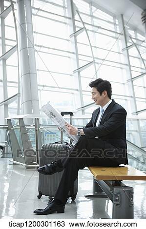 a businessman reading a newspaper in the airport View Large Photo Image Stock Image - a businessman reading a newspaper in the airport. Fotosearch