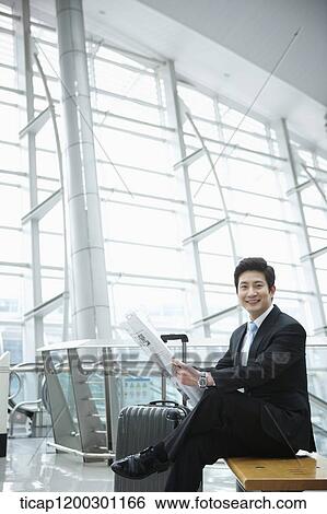 a businessman reading a newspaper in the airport View Large Photo Image Stock Photograph - a businessman reading a newspaper in the airport. Fotosearch
